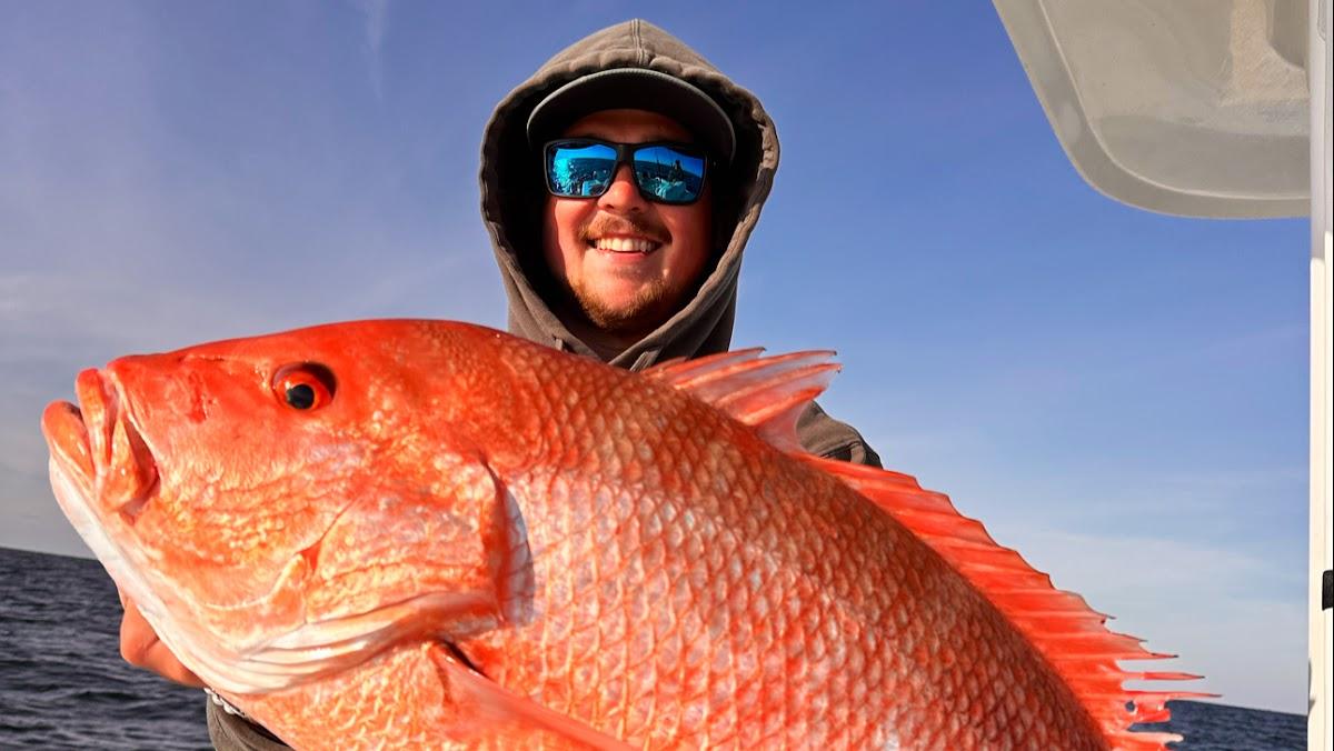Happy angler holding a large Red Snapper caught with O Sea D Fishing Charters in Destin, Florida.